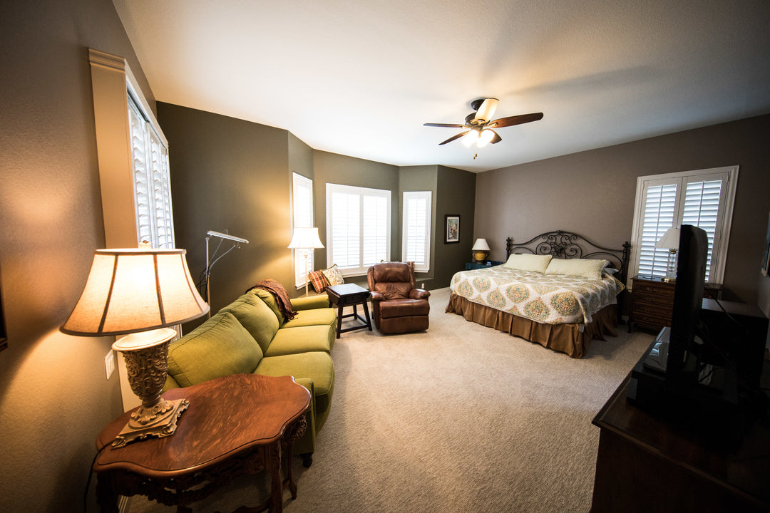 Pioneer television in large bedroom with couch and recliner.